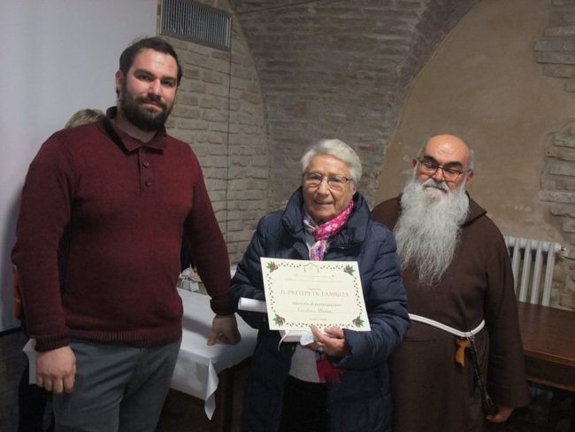 Padre Giulio Criminesi e Leandro Messi  premiano Elodia per il suo presepe